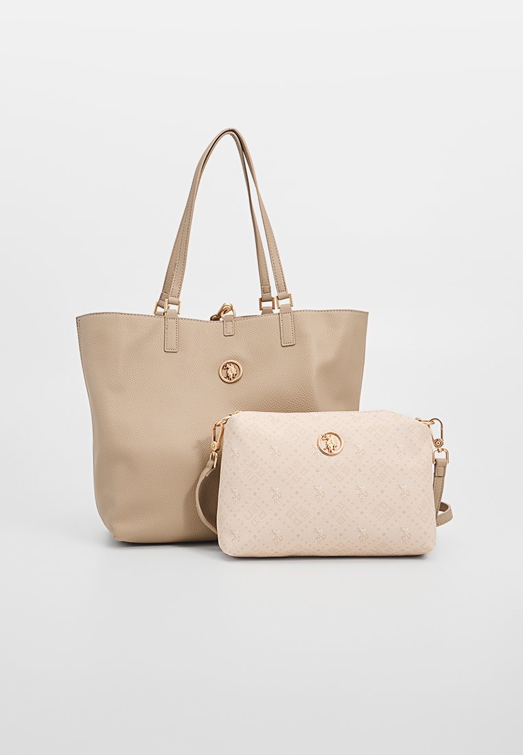 Sac fourre-tout en cuir beige avec double anses et quincaillerie dorée, accompagné d'une pochette beige plus petite à motif, ornée d'un logo doré.