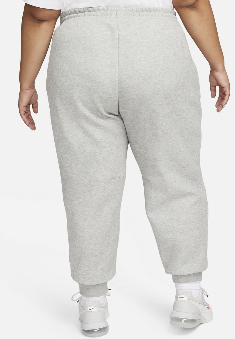 Helle graue Sweatpants mit einem elastischen Bund, Bündchen an den Knöcheln und einer glatten Textur. Getragen mit weißen Sportschuhen.