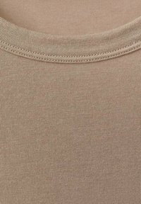 Beige Baumwoll-T-Shirt mit einer glatten, gerippten Textur, einem runden Halsausschnitt und sauber genähten Kanten.