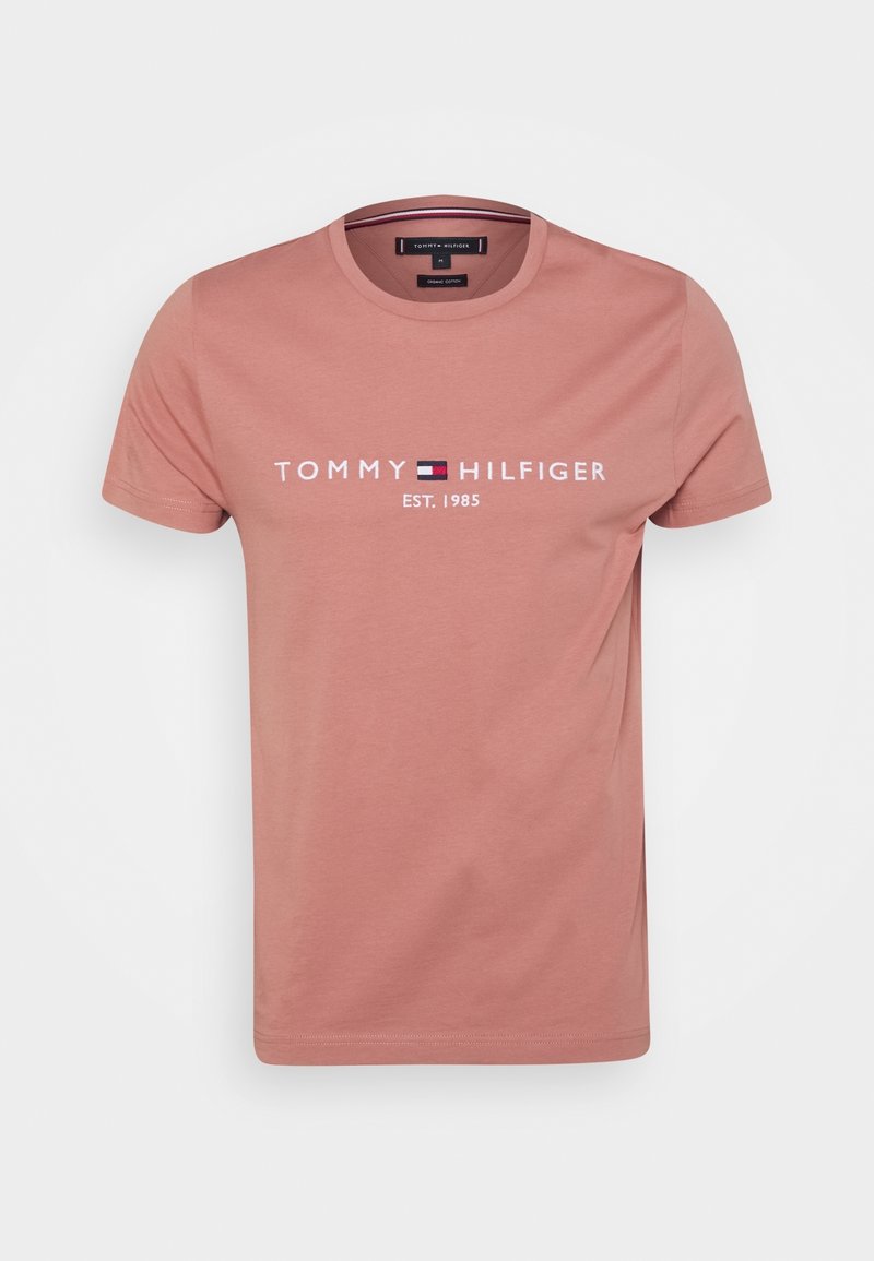 Pink cotton t-shirt with a crew neck, featuring "TOMMY HILFIGER EST. 1985" printed in white, with a blue and red logo accent.