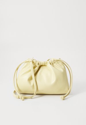 Yellow leather bag with a gathered design, adjustable drawstring closure, and a single long strap. Minimal branding at the base.