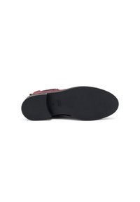 Scarpa in suede rossa con suola piatta in gomma nera, caratterizzata da cuciture minime e una superficie testurizzata. Il design è elegante con una silhouette semplice.