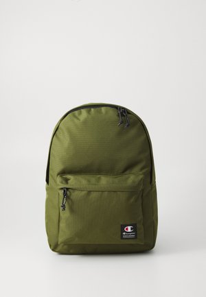 Olive roheline kangast seljakott, millel on ümar kuju, ees on lukuga tasku ja logopatch. Must tõmblukk ja detailid. Vastupidav materjal.