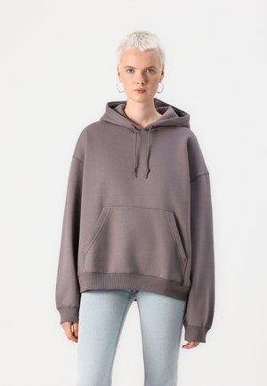 Hoodie surdimensionné en gris doux, avec une poche avant, un capuchon à cordon de serrage et des poignets côtelés. Tissu en mélange de coton lisse, coupe décontractée.