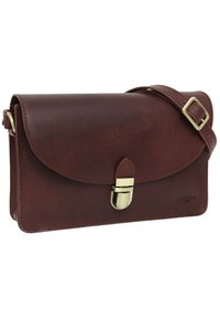 Braune Leder-Clutch mit einer Klappenöffnung, Messingbeschlägen und einem verstellbaren Träger. Glatte Textur mit minimalen Nähdetails.