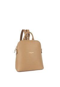 Sac à dos en cuir beige avec une forme arrondie, deux bretelles, poignées supérieures et un détail de logo doré. Fermeture éclair sur le côté.
