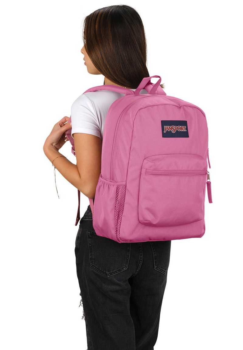 Roze Jansport rugzak gemaakt van duurzaam stof, heeft een hoofdcompartiment, een frontzak, een zijnetzak en verstelbare schouderbanden.