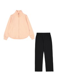 Chaqueta con cremallera de melocotón con dos bolsillos delanteros y pantalones de chándal negros. Ambos están hechos de una tela suave, presentan un ajuste relajado y cintura elástica.