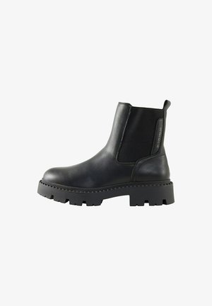Stivaletti in pelle nera con pannelli elastici sui lati, suola in gomma spessa, superficie texture e una linguetta sul retro per agevolare la calzata.