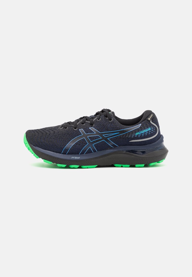 Chaussure de course noire et bleue avec des accents verts sur la semelle, design bas, semelle intermédiaire coussinée et tige en mesh respirant sur fond blanc.