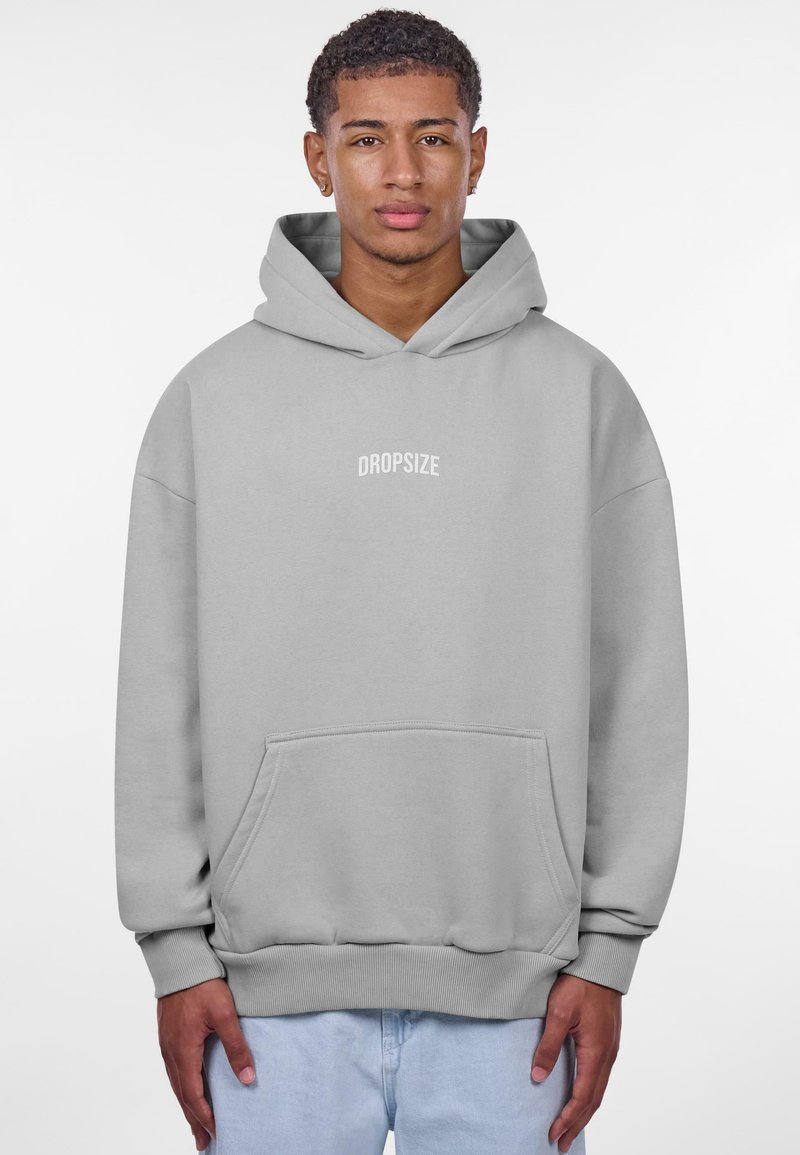 Grå hættetrøje med frontlomme og snøre i hætten. Udstyret med et iøjnefaldende hvidt "DROPSIZE" logo centreret på brystet. Blød tekstur og afslappet pasform.