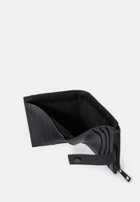 Carteira de couro preto com vários slots para cartões, compartimento com fecho éclair e fecho de pressão. Textura suave e design estruturado.