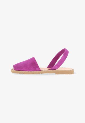 Sandale slingback en suède magenta avec un bout fermé, une semelle en caoutchouc plate beige, et un design à une seule sangle pour un maintien sécurisé.