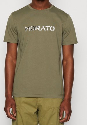 Man draagt een olijfgroen T-shirt met korte mouwen met de tekst "MORATO" en bijpassende olijfgroene cargobroek, staand tegen een effen achtergrond.