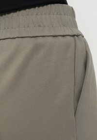 Gray pants made of soft fabric with an elastic waistband and side seam details. The texture appears smooth and slightly stretchy.