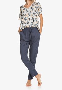 Top corto de flores ligero con cuello en V; combinado con pantalones de tiro relajado de corte nave azul con cordón; presentación de tela suave.