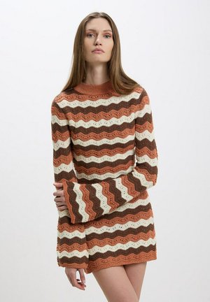 Maglione lavorato a maglia con maniche lunghe e svasate. Presenta un motivo ondulato nei colori ruggine, marrone e crema. Collo a coste e tessuto testurizzato.
