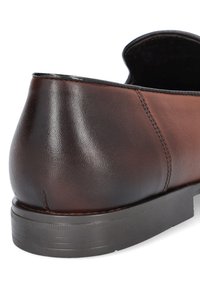 Brązowy skórzany but o gładkim, błyszczącym wykończeniu, zakrzywionym obcasie i kontrastowym, tonalnym przeszyciu. Gumowa podeszwa z delikatnymi żłobieniami.