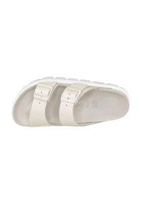 Sandali beige chiaro con due cinturini regolabili dotati di fibbie. Suola bianca spessa con superficie strutturata. Fodera interna liscia.