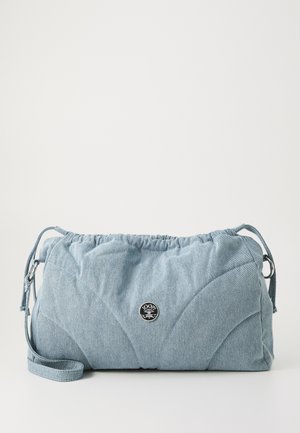 Denim skuldertaske i lyseblå med samlet top, justerbar rem og cirkulær logo-accent; quiltet tekstur med buede søm mønstre.