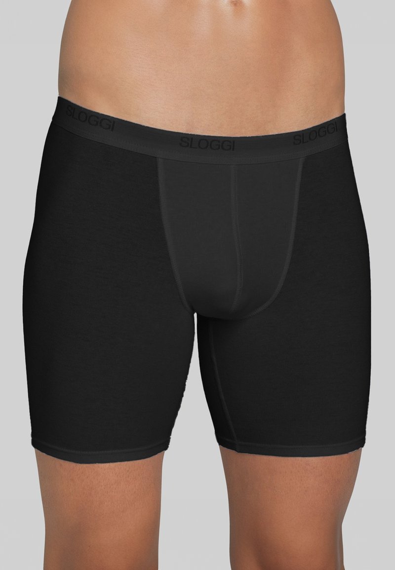 Boxer di colore nero realizzati in tessuto morbido, con una cintura confortevole su cui è riportato il marchio "SLOGGI". Texture liscia, lunghezza fino a metà coscia.