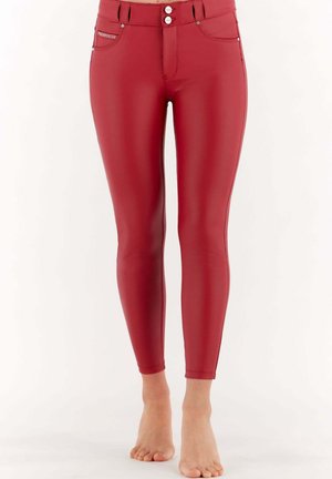Leggings rossi a vita alta con una superficie liscia e lucida. Presentano due bottoni frontali, tasche e un design aderente che si restringe alle caviglie.