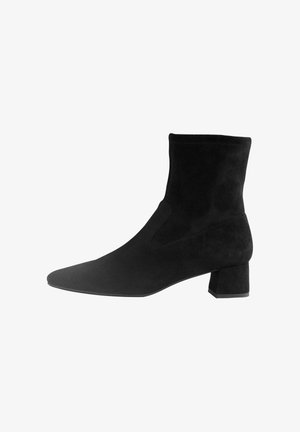 Schwarze Wildleder-Ankle-Boots mit spitzer Zehenpartie und einem mittelhohen Blockabsatz. Mit elastischen seitlichen Einsätzen für einfaches An- und Ausziehen. Glatte Oberfläche.