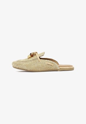 Slip-on woven beige mule with round wooden bead accents and tan sole, featuring a flat heel and casual design.