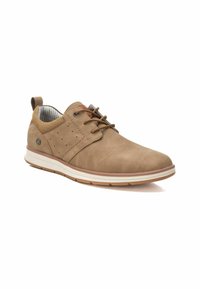 Zapato de cuero perforado marrón con forro textil gris, puntera redonda, diseño con cordones y suela de goma con una franja blanca contrastante.