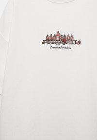 Echipa de baschet în uniforme roșii și albe, așezată pe o bancă, cu antrenorul îngenuncheat, textul „La passion fait la force” dedesubt.