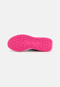 La suola della scarpa sportiva presenta una superficie in gomma rosa testurizzata con un motivo di battistrada triangolare e un logo stampato, progettata per offrire aderenza e trazione.