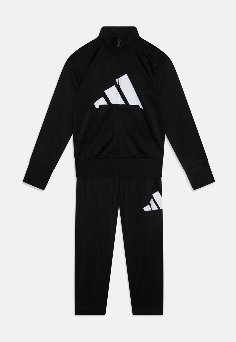 Survêtement noir en matériau léger, comprenant une veste zippée avec le logo Adidas blanc et un pantalon assorti avec un placement de logo similaire.