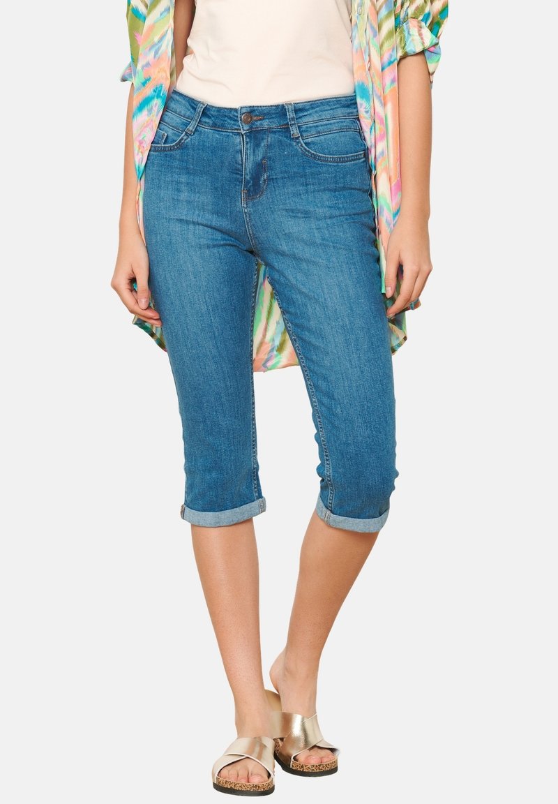 Gaiši zilas denima kapri bikses ar salocītu piedurkni, ar priekšējiem kabatām un pogu aizdari, apvienotas ar modeļu kimono un sandaļiem.