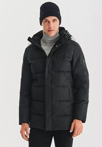 Czarna kurtka puchowa z pionowymi szwami i zamkiem z przodu. Posiada kaptur, dwie boczne kieszenie oraz dzianą czapkę.