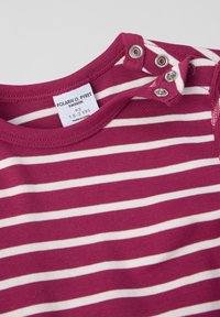 Maroon ja valge triibuline puuvillane särk ümmarguse kaelusega, millel on õlavarre kohal nupud. Silt on nähtav koos suuruse ja brändi detailidega.