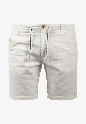Shorts beige clair en tissu doux. Dotés d'une fermeture à bouton, d'un cordon de serrage et de revers roulés. Deux poches sur les côtés.