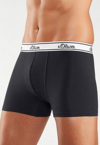Black boxer briefs made of cotton, featuring a white elastic waistband with "s.Oliver" logo. Smooth texture and fitted design.