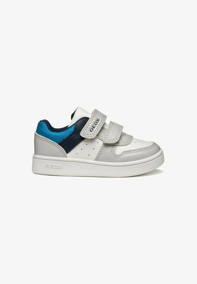 Zapatillas deportivas grises y blancas con detalles en azul y azul marino. Cuentan con dos tiras de velcro, detalles perforados y una suela de goma.