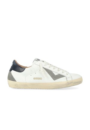 Sneaker bianca in pelle con accenti grigi e neri, caratterizzata da un pannello in suede testurizzato e una punta rotonda. Include lacci piatti e dettaglio del logo.