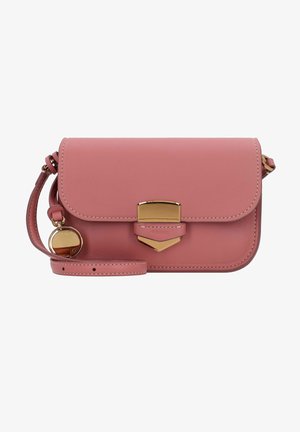 Sac bandoulière en cuir rose avec fermeture dorée et breloque ronde dorée suspendue à la sangle réglable sur fond blanc.