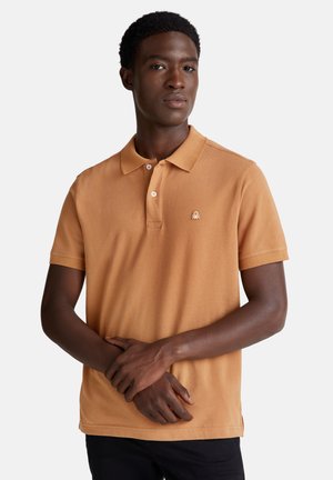 Koszulka polo z krótkim rękawem w miękkim pomarańczowym odcieniu, z trzema guzikami i haftowanym logo na lewej piersi, wykonana z oddychającego materiału.
