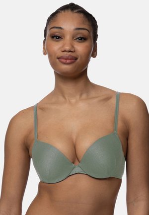 Soutien-gorge push-up moulé en tissu vert doux avec une surface texturée. Dispose de bretelles réglables et d'un design sans coutures pour un ajustement lisse.