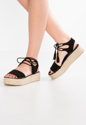 Sorte ruskind espadrille-sandaler med åben tå, snørre-design og frynse-detaljer. Med en kile-sål indsvøbt i jute.