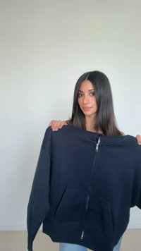 Tamno plavi dukserica od mekanog materijala sa zatvaračem, kengur džepom i dugim rukavima. Karakterizira opušten kroj i minimalistički dizajn.