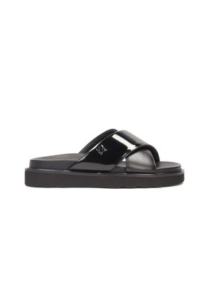 Black slide sandals with glossy patent leather upper, cross-strap design, and thick black rubber sole featuring a wavy edge.