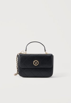 Μαύρη τσάντα χειρός από καπιτονέ δέρμα με χρυσή αλυσίδα και πάνω λαβή, με κυκλικό χρυσό έμβλημα με το γράμμα "V" στο εμπρός καπάκι.