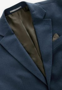 Marineblauer Blazer mit einer strukturierten Stoffoberfläche. Das Innere verfügt über ein gemustertes dunkelgrünes Futter und ein Einstecktuch in der Brusttasche.