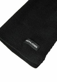 Zwart gebreide stof met een klein rechthoekig Jack & Jones merklabel genaaid vlakbij de rand.