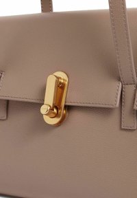 Strukturierte Handtasche aus weichem Leder in Taupe, mit einem Verschluss in Goldoptik, flachen Trägern und gesteppten Details. Minimalistisches Design mit glatter Textur.