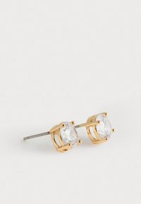 Cercei cu tijă din metal de culoare aurie, înfăcându-se din strass-uri rotunde clare, prinse într-un design cu patru colți, având un pin de argint pentru prindere.